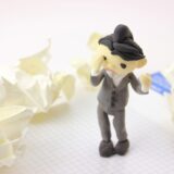 夫が亡くなった後の手続きに悩む妻をイメージした人形